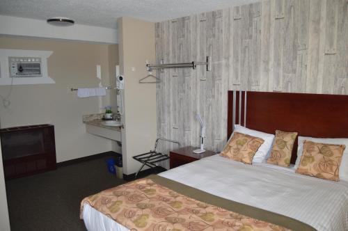 a bedroom with a large bed with a wooden headboard at Wheel Inn Motel in Assiniboia