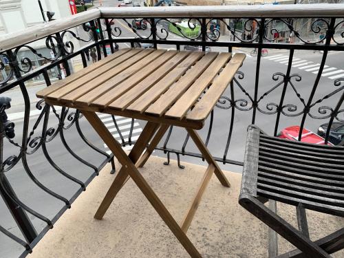 a wooden table and a bench on a balcony at Chambres EL MEDITERRANEO Rooms in Montréal