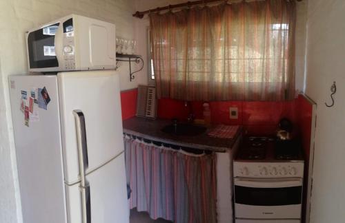 a small kitchen with a refrigerator and a sink at Las Casuarinas in Piriápolis