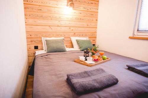 a bedroom with a bed with a tray of fruit on it at Domki na Łazach in Uherce Mineralne (7)