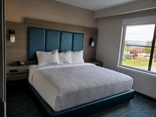 a bedroom with a large bed with a large window at salish Inn in Anacortes