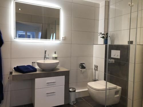 a bathroom with a sink and a toilet and a mirror at Stadtoase in Emden