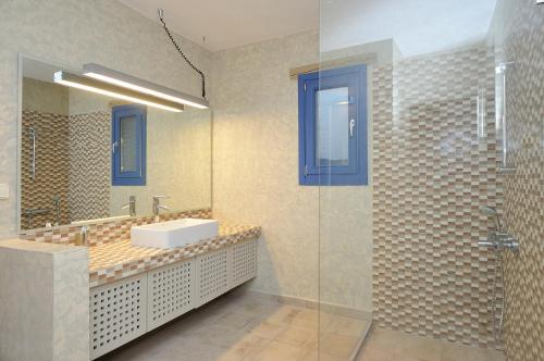 a bathroom with a sink and a glass shower at VILLA SOROS in Antiparos