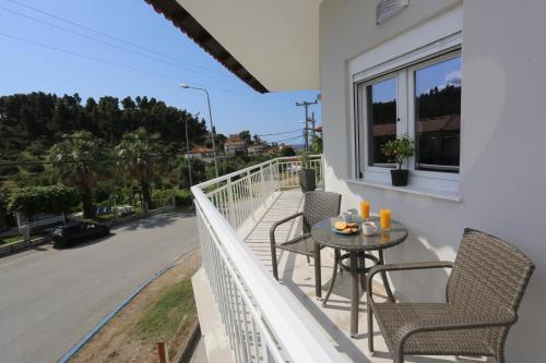 a balcony with a table and chairs and a street at Mare Monte Luxury Apartments 2 in Nea Skioni