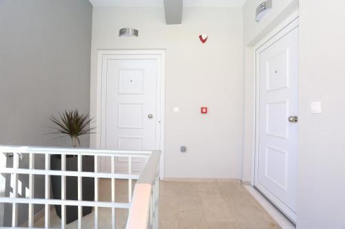 a white hallway with a staircase and white doors at Mare Monte Luxury Apartments 2 in Nea Skioni