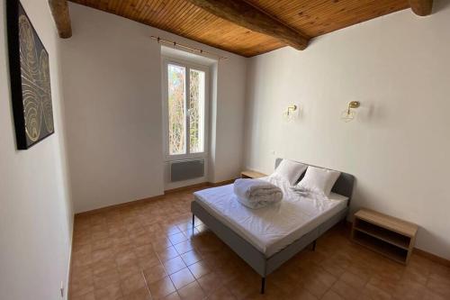 1 dormitorio con cama y ventana en Très beau appartement au centre historique de Riez en Riez