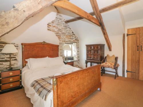 a bedroom with a bed and a stone wall at Glanville House in Mevagissey