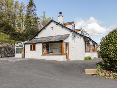 a white house with orange windows and a driveway at Green Acre in Ulverston