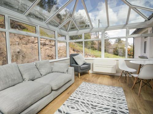 a living room with a couch in a conservatory at Green Acre in Ulverston