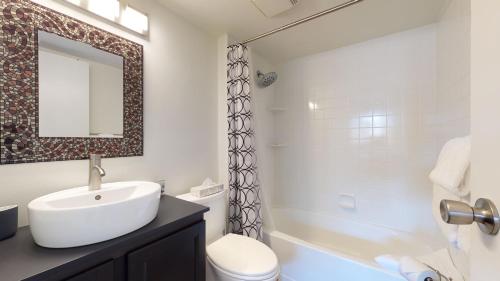 a bathroom with a sink and a toilet and a shower at Beautiful Marketplace Condo with Mountain Views in Whistler
