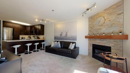 a kitchen and a living room with a fireplace at Beautiful Marketplace Condo with Mountain Views in Whistler