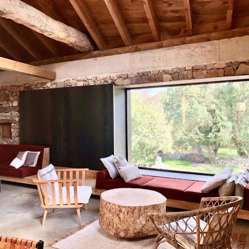 a living room with a large window and a couch at El pajar de abajo - Pedraza - in La Alameda