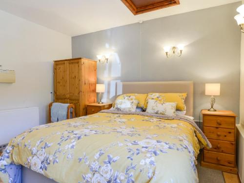 a bedroom with a bed with yellow and blue bedding at Miners Dry in Gunnislake