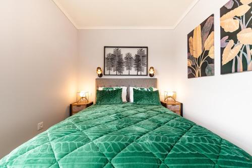 a bedroom with a green bed with two green pillows at Pico Studios in Madalena