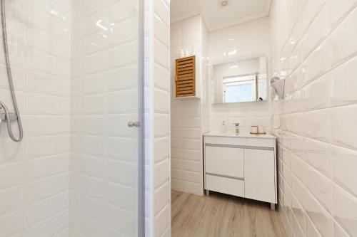 a white bathroom with a shower and a sink at Pico Studios in Madalena