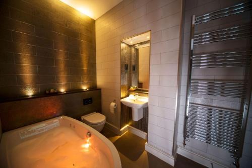 a bathroom with a tub and a toilet and a sink at East Walls Hotel in Chichester