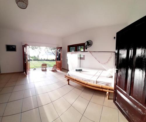a bedroom with a bed on a tiled floor at Merdeka House in Maluk