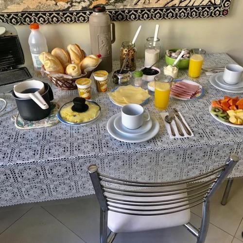 a table with breakfast foods and drinks on it at Suítes e Quartos na Avenida Carlos Gomes não tem garagem in Porto Alegre