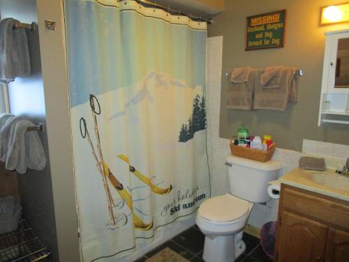 a bathroom with a shower curtain with a dog on it at The Wüdenknipple in Bessemer