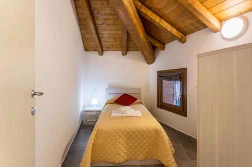 une chambre avec un lit avec un couvre-lit jaune dans l'établissement COTTAGE GIULIA, à Argegno