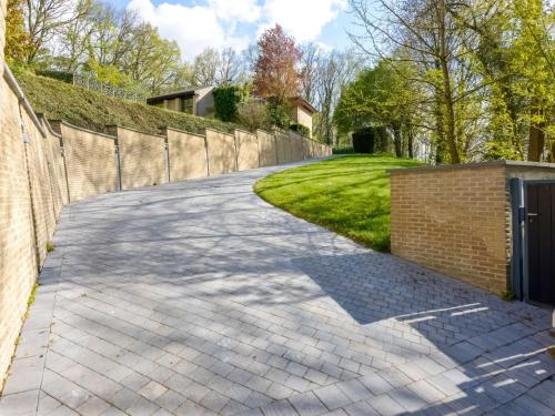 a driveway in front of a brick fence at Picturesque villa with swimming pool in Bierges