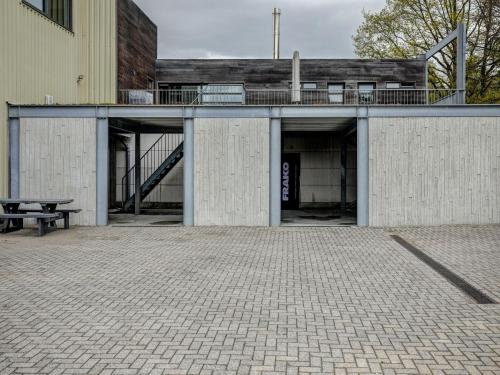 un edificio con terraza y banco en un patio en Classy Apartment in Weelde with Swimming Pool, en Weelde