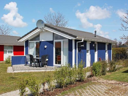 Casa azul y blanca con mesa y sillas en 4 person holiday home in GROEMITZ, en Grömitz