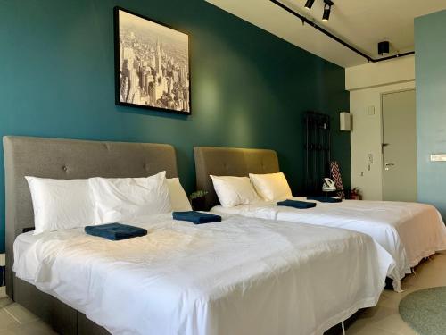 dwa łóżka siedzące obok siebie w pokoju w obiekcie Cozy Tamarind Suites w mieście Cyberjaya
