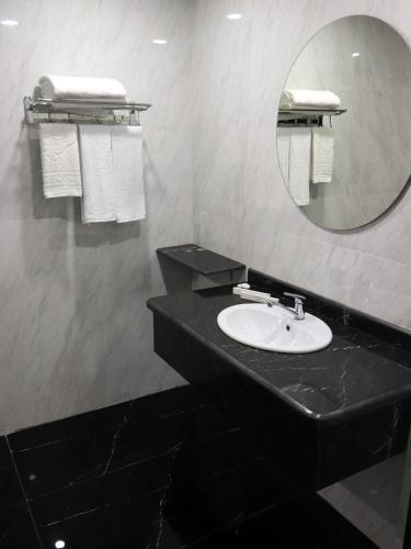 a bathroom with a black sink and a mirror at East Palace Hotel in Almaty