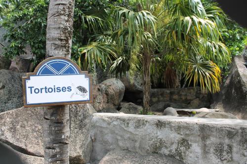 a sign on a pole in front of a zoo at Hotel Chateau St Cloud in La Digue