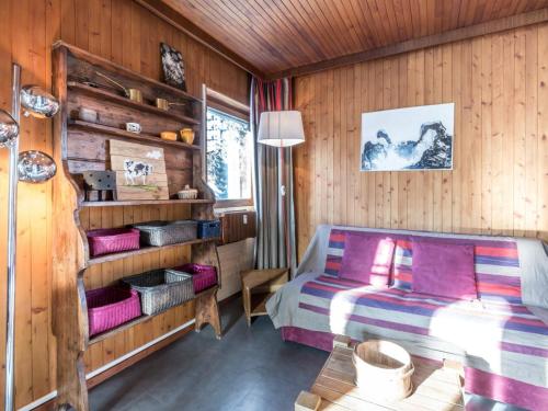 ラ・クリュサにあるAppartement La Clusaz, 2 pièces, 4 personnes - FR-1-304-47の木製の壁のベッドルーム1室(ベッド1台付)