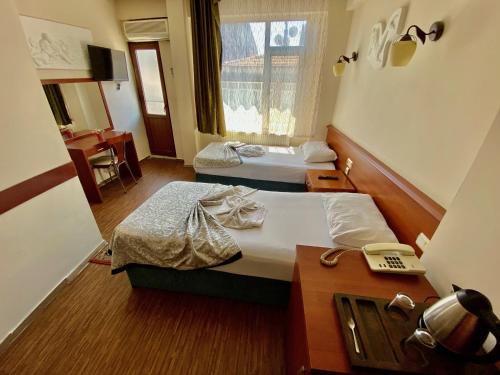 イスタンブールにあるカデュキョイ ケルヴァンサライ ホテルのベッド2台とデスクが備わるホテルルームです。