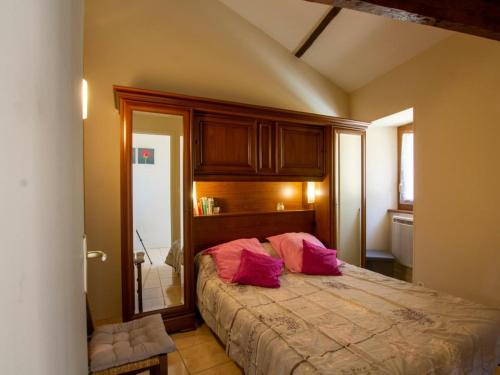 Un dormitorio con una cama con almohadas rosas. en Gîte La Roque-Gageac, 2 pièces, 2 personnes - FR-1-616-28, en La Roque-Gageac