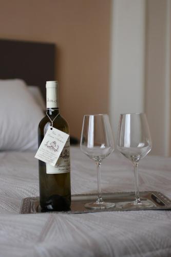 a bottle of wine and two wine glasses on a bed at Hotel Regina Margherita in Bordighera