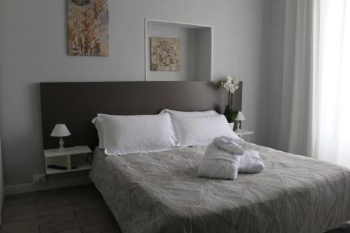 ein Schlafzimmer mit einem Bett mit einem ausgestopften Tier darauf in der Unterkunft Hotel Regina Margherita in Bordighera