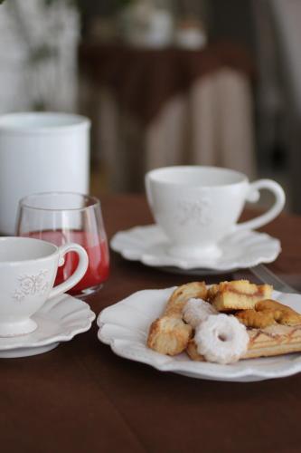 a table with two cups and a plate of food at Hotel Regina Margherita in Bordighera