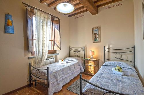 1 Schlafzimmer mit 2 Betten und einem Fenster in der Unterkunft Agriturismo Lodolazzo in Cortona