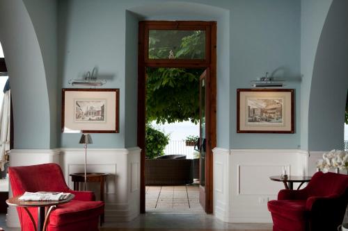 a hallway with two red chairs and a door at Hotel Riviera & Maximilian's in Trieste