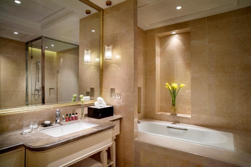 a bathroom with a sink and a tub and a mirror at The Sebel Xining-Managed By Sofitel in Xining