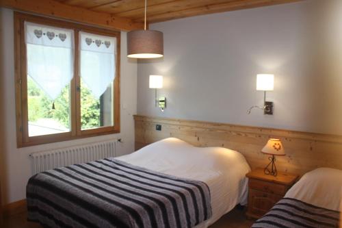 um quarto com 2 camas e uma janela em Résidence Chalet des Granges em Samoëns