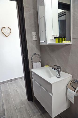 a bathroom with a white sink and a mirror at Ayia Napa Boutique Apartments in Ayia Napa