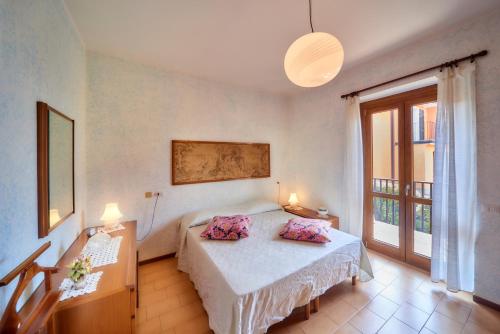 um quarto com uma cama com almofadas cor-de-rosa em Casa della Zia em Abbadia Lariana