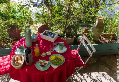 a table with a red table cloth with food on it at Marie Colline à la Campagne in Saint-Antonin