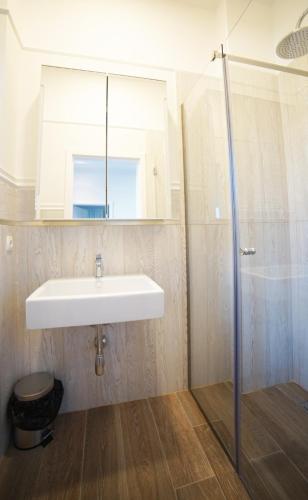 W łazience znajduje się biała umywalka i prysznic. w obiekcie City apartments T w mieście Satu Mare
