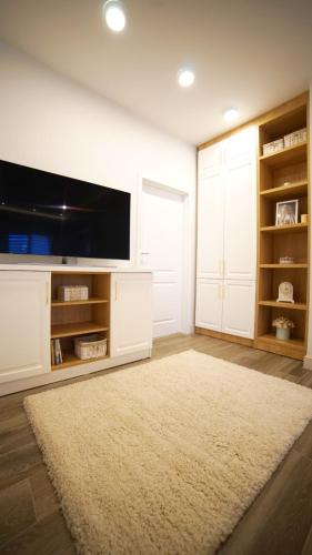 salon z telewizorem i dywanem w obiekcie City apartments T w mieście Satu Mare