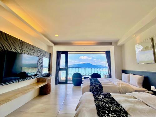 a bedroom with two beds and a view of the ocean at Ming Yue Hu Hotel in Yuchi