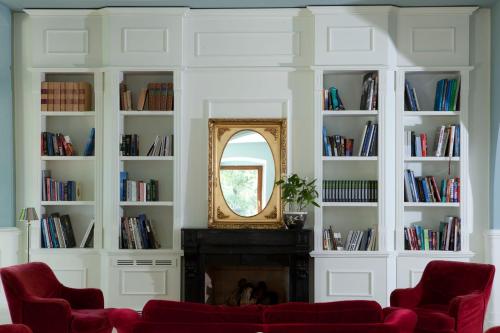 a living room with a fireplace and a mirror at Hotel Riviera & Maximilian's in Trieste