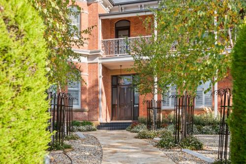 a brick building with a door and trees at The Rivulet in Hobart