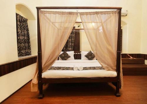 a bed with a canopy in a room at Westend Hotel in Matheran