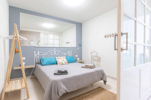 een blauwe slaapkamer met een bed en een ladder bij Apartamento Corazón Playa in Corralejo
